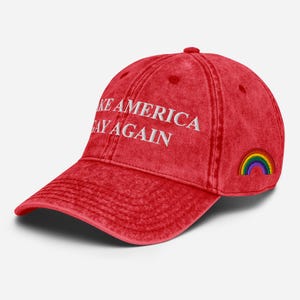 Könnte beinhalten: Rote Baseballkappe mit dem Text "Make America Gay Again" in weißer Stickerei und einem gestickten Regenbogen an der Seite.