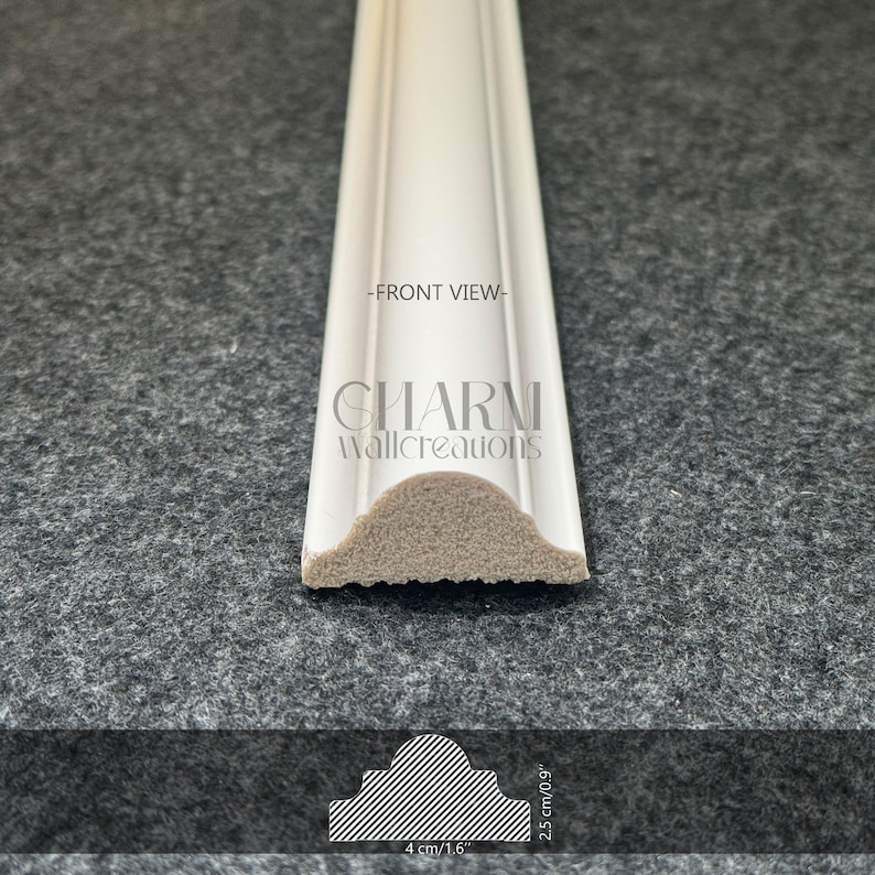 May include: White decorative molding with a rounded top edge. The molding is 4 inches wide and 2.5 inches tall. The text "CHARM wallcreations" is printed on the molding. -FRONT VIEW-