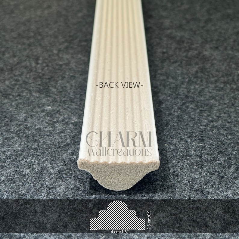 May include: Back view of a white, fluted, decorative molding with a rounded edge. The molding is 4 inches wide and 2.5 inches tall. The text "CHARM Wallcreations" is printed on the molding.