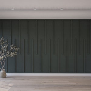 K&ouml;nnte beinhalten: Ein minimalistisches Innendesign mit einer dunkelgr&uuml;nen Akzentwand mit vertikalen Holzpaneelen. Ein kleiner wei&szlig; bl&uuml;hender Baum in einer braunen Vase steht in der Ecke des Raumes.