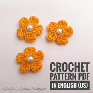 May include: Three crocheted yellow flowers with white pearl centers. Crochet pattern PDF in English (US).