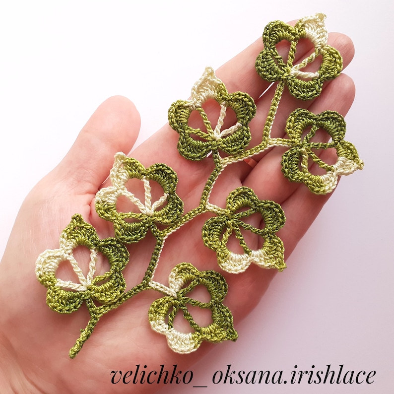 May include: A crocheted green and white leaf design with a delicate, intricate pattern. The design is made with a combination of green and white yarn, creating a beautiful contrast.
