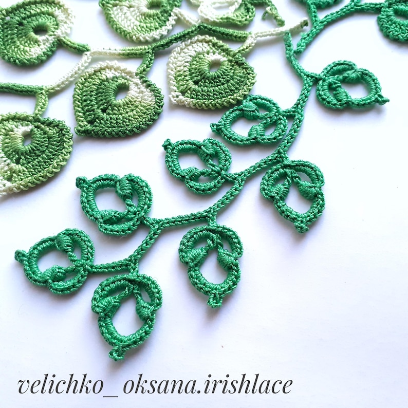 May include: Green crocheted lace with a leafy design. The lace is made with a delicate stitch and has a light, airy feel.