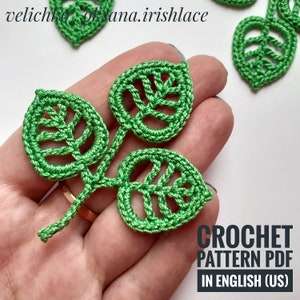 May include: Close-up of several green crochet leaf appliques. The leaves have detailed vein patterns and are connected by stems. The text "CROCHET PATTERN PDF IN ENGLISH (US)" is visible in the lower right corner.