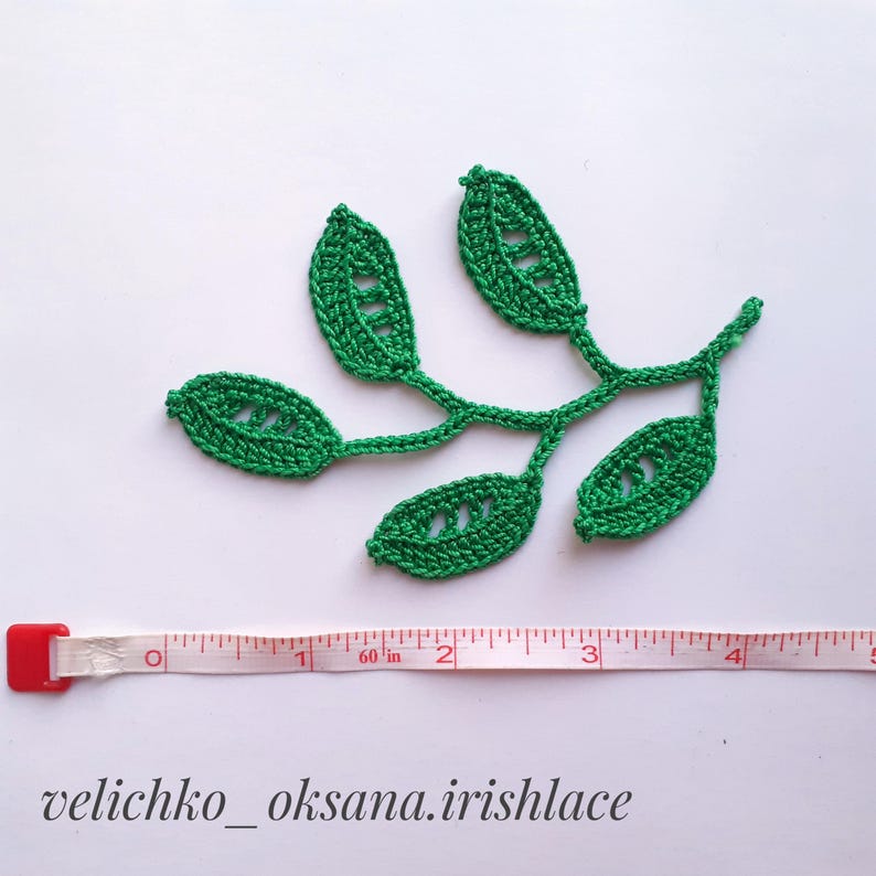 May include: Green crocheted leaf motif with a stem and five leaves. The motif is approximately 4 inches wide.