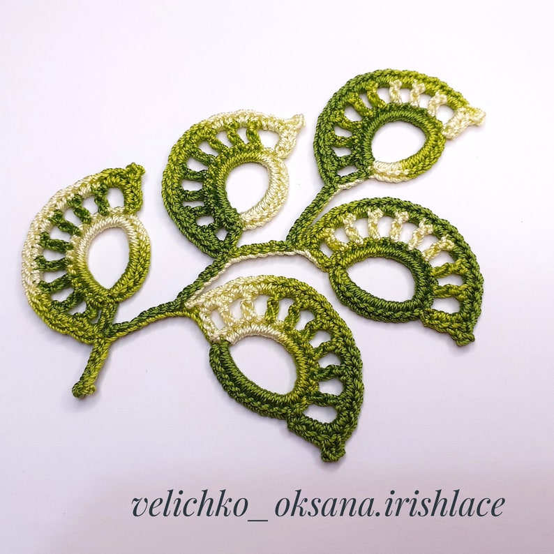May include: A crocheted green and white leaf design with a delicate, lacy pattern. The design is reminiscent of a branch with multiple leaves. The text "velichko_oksana.irishlace" is visible at the bottom of the image.