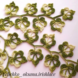 May include: A delicate crocheted lace design featuring a vine with green and cream leaves. The leaves are intricately detailed and create a beautiful pattern.
