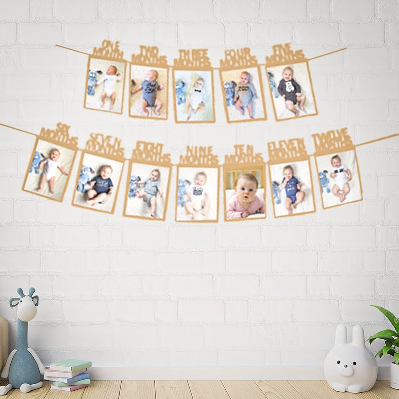 May include: A brown paper photo banner with 12 frames for pictures. Each frame has a white card with the words "One Month", "Two Months", etc. up to "Twelve Months".