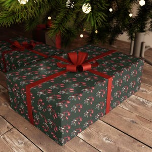Puede incluir: Dos cajas de regalo rectangulares envueltas en papel verde oscuro con un patrón repetitivo de langostas rojas y flores blancas. Cada caja está atada con una cinta roja lisa y sólida que forma un lazo decorativo en la parte superior central.