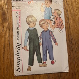 Può includere: Modello di cucito Simplicity numero 6157 per bambini di taglia 1. Il modello è per salopette con due stili a scelta. Il modello è stampato in Canada e costa 50 centesimi.