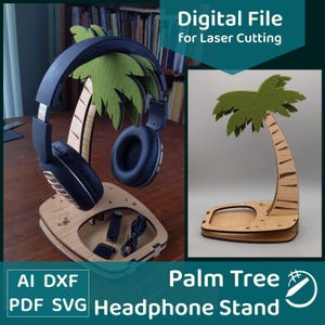 Könnte beinhalten: Ein Kopfhörerständer aus Holz in Form einer Palme mit grüner Filzwedel. Der Ständer hält schwarze Kopfhörer und hat eine kleine Ablage für Zubehör. Der Text auf dem Bild lautet "Digital File for Laser Cutting" und "Palm Tree Headphone Stand."