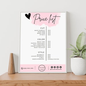 Op de afbeelding: Een ingelijste prijslijst voor een kapsalon, met een roze aquarel-achtige achtergrond en een zwart hart. De lijst bevat diensten zoals knippen, kleuren en stylen, met prijzen. Een logo en contactgegevens staan onderaan.