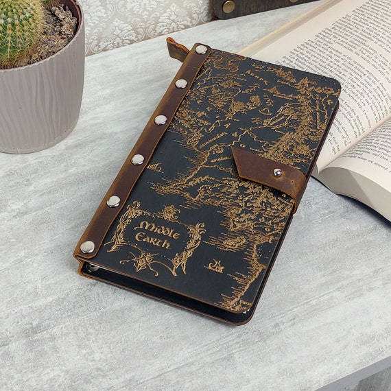 A hand-tooled leather journal featuring an engraved Middle-Earth map — it's a refillable Tolkien artifact, not just a notebook.