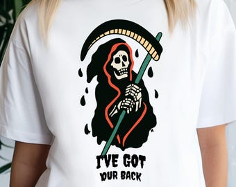 May include: White t-shirt featuring a Grim Reaper graphic with a black cloak, holding a scythe. The design includes the text "I've Got Your Back" in a bold font. The shirt is a casual wear item.