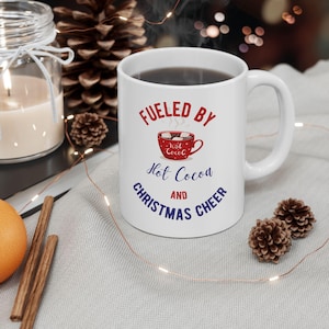 Angetrieben durch heißen Kakao und Weihnachtsbeifall, festliches heißes Kakaogeschenk, Wintertasse, saisonaler Kaffeeliebhaber, Weihnachtstasse für Urlaubsliebhaber