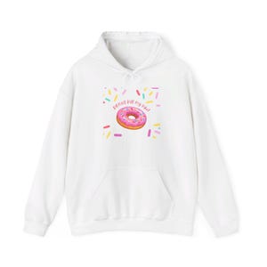 May include: White hoodie featuring a pink and white donut graphic with the text "Donut kill my vibe". The donut is surrounded by colourful sprinkles.