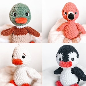 May include: Four crocheted stuffed animals: a green duck, a pink flamingo, a white duck, and a black and white penguin. All four animals have red beaks and black eyes.