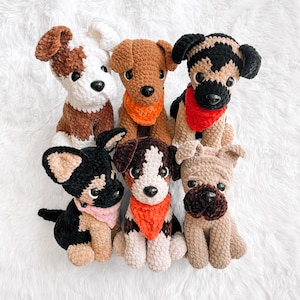 May include: A collection of six handmade crochet dog plushies in various breeds and colors. Each dog has a unique design, with some wearing bandanas. The dogs are brown, white, black, and tan, with black button eyes and black noses.