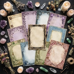 Op de afbeelding: Een verzameling papieren vellen in vintage-stijl met sierlijke randen, gerangschikt op een donker houten oppervlak. De vellen hebben verschillende ontwerpen, waaronder manen, kruiden en scharen. Amethistkristallen, kaarsen en gedroogde bloemen omringen de papieren, wat een mystieke esthetiek creëert.