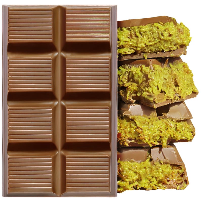 May include: A milk chocolate bar with a segmented design, next to a stack of broken chocolate pieces filled with a green, textured filling. The chocolate is a light brown color, and the filling has a vibrant green hue.