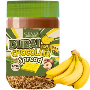 May include: A jar of Dubai Banana Chocolate Spread with a green lid and a label featuring a banana graphic. The label also includes the text "Dubai Chocolate Spread" and "9.7 Oz (275g)". A bunch of ripe bananas is next to the jar.