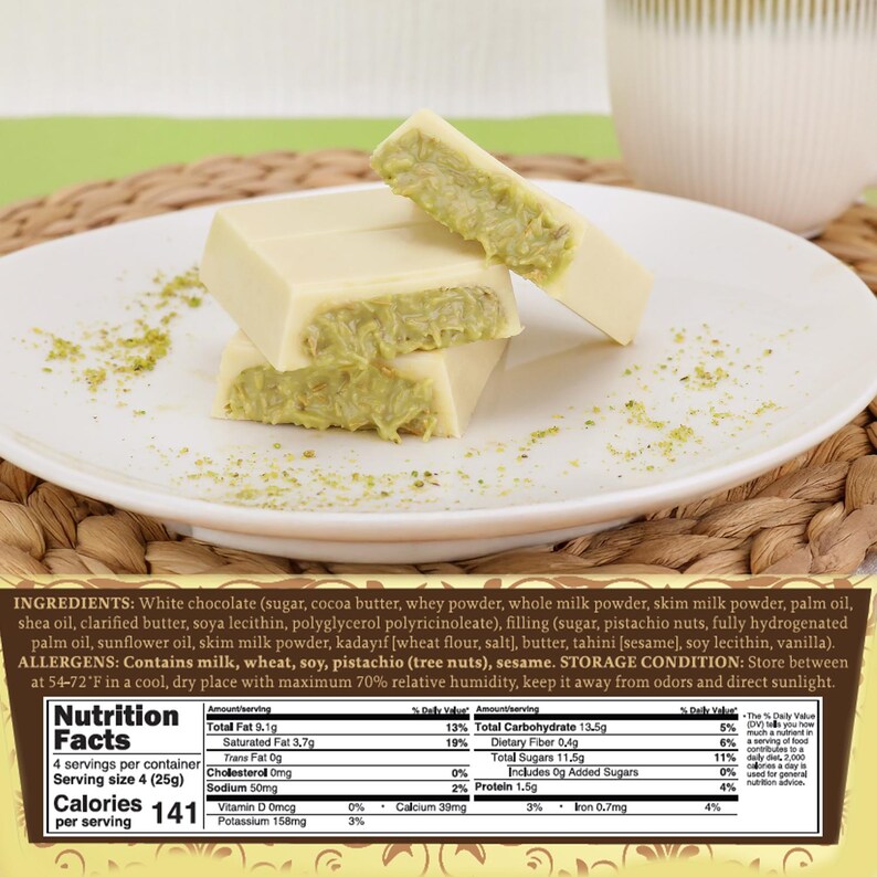 May include: White chocolate bars with a pistachio filling are stacked on a white plate. The bars are cut to reveal the green filling. A cup of liquid is in the background. The nutrition facts are visible.