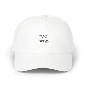 Può includere: Un cappellino da baseball bianco con visiera curva. Il cappellino presenta la scritta "FMC energy" ricamata in nero sul davanti. Il cappello è realizzato in un materiale morbido e ha uno stile classico e casual.