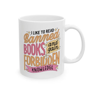 May include: White ceramic mug with a pink and orange design that says "I like to read banned books and gain forbidden knowledge".