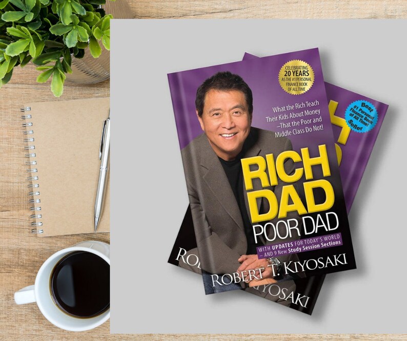 Puede incluir: Se muestran dos ejemplares de "Rich Dad Poor Dad" de Robert T. Kiyosaki. Las portadas de los libros presentan el retrato de un hombre sobre un fondo morado. El texto incluye "Celebrating 20 Years" y "#1 Personal Finance Book of All Time."