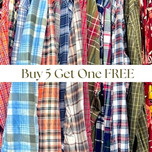 May include: A collection of plaid shirts in various colors, including blue, red, green, and orange, hanging on a clothing rack. The shirts have different plaid patterns. Text across the image reads "Buy 5 Get One FREE."