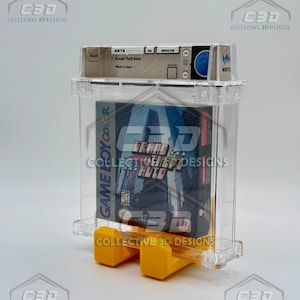 Könnte beinhalten: Eine transparente Kunststoff-Vitrine mit einer Grand Theft Auto Game Boy Color-Spielkassette. Die Vitrine hat gelbe Stützen und den Text "DIGITAL DOWNLOAD - NOT PHYSICAL ITEM" unten.
