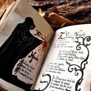 May include: An open book with a black and white illustration of a hooded figure on the left page. The right page has handwritten text in black ink, including the title "To Vanish Masselin" and a recipe for a potion. The text reads: "A collection of Myrrh bark, Mixed with Sarresh, Along with crushed Bear Root, In Water so Fresh. Stir these together, Bind them as one, Contribute Crow Feathers, Now, cast it soon done. The Demon must drink this To relinquish his victims, To conquer this foul broth Is his benediction."