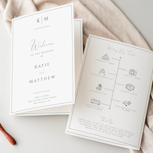 May include: A wedding invitation with a black and white design. The front of the invitation says "Welcome to the wedding of Katie and Matthew" with the date and location below. The back of the invitation has a timeline of the wedding day with icons for each event.