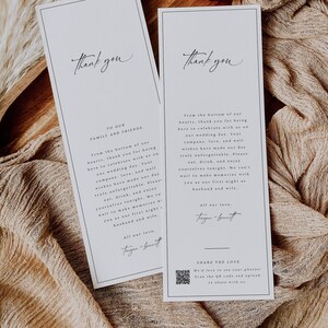 Könnte beinhalten: Zwei elegante weiße Hochzeits-Dankeskarten mit schwarzem Text. Die Karten haben ein schlichtes Design mit den Worten "Thank You" oben und einer herzlichen Botschaft darunter. Die Karten liegen auf einem Holztablett mit Trockenblumen und Stoff.