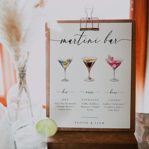 May include: A sign for a martini bar with three illustrated cocktails. The sign is labeled "martini bar" with the drinks labeled "his", "ours", and "hers". The drinks are labeled with their ingredients: "Dry", "Espresso", and "Cosmo". The sign is signed "Eloise & Liam".