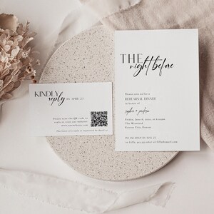 May include: A white RSVP card with black text. The text reads "Kindly reply by April 23". A QR code is included with the text "Please scan the QR code to reply or visit our website: www.ourwebsite.com. The favor of a reply is requested by April 23". A second white card with black text reads "The night before". The text continues "Please join us for a rehearsal dinner in honor of Sophie + Jackson. Friday, June 8, 2023, at 6:00pm. The Winstend, Kansas City, Kansas. Please RSVP by May 23 to Lilly, 913.333.0809 or lilly@email.com."