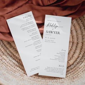 Könnte beinhalten: Ein Programm für eine Hochzeitszeremonie mit den Namen Madelyn und Sawyer, dem Datum 6.7.202X und dem Ort The Sawyer Room, Kansas City, Missouri. Das Programm listet den Standesbeamten, die Eltern der Braut und des Bräutigams, die Trauzeugin, den Trauzeugen, die Brautjungfern, die Trauzeugen, die Blumenmädchen und den Ringträger auf.