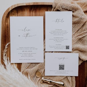 May include: White wedding invitation suite with a minimalist design. The invitation features the couple's names, "Elise + Rethin", the date "06.07.2021", and the location "St. Anne's Chapel, Kansas City, Missouri". The details card includes information about the reception, accommodations, and a QR code for more details. The RSVP card features a QR code and the text "RSVP by April 1st".