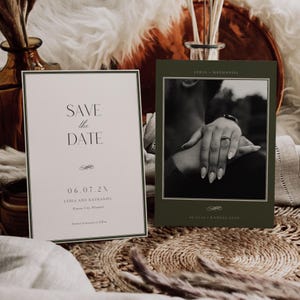 Puede incluir: Dos tarjetas de anuncio de boda. Una tarjeta tiene el texto "SAVE the DATE" en una fuente serif. La otra tarjeta tiene una foto en blanco y negro de las manos de una pareja. Las tarjetas están sobre una superficie tejida.