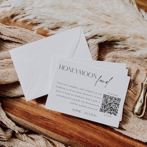 Könnte beinhalten: Weiße Karten mit dem Schriftzug "HONEYMOON fund" in schwarzer Schrift. Die Karten enthalten einen QR-Code und Text, der um Beiträge bittet. Ein weißer Umschlag und dekorative Elemente befinden sich im Hintergrund.
