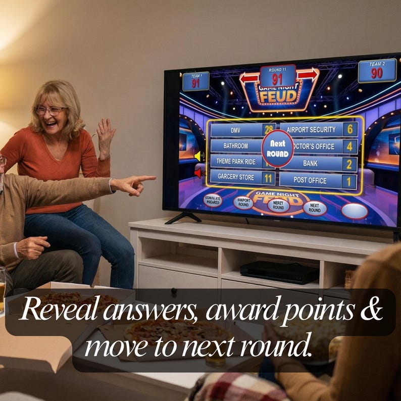 May include: A television screen displays a game show interface with the words "Game Night Feud." The screen shows categories and point values. The text "Reveal answers, award points & move to next round" is at the bottom of the image. People are visible in the image.