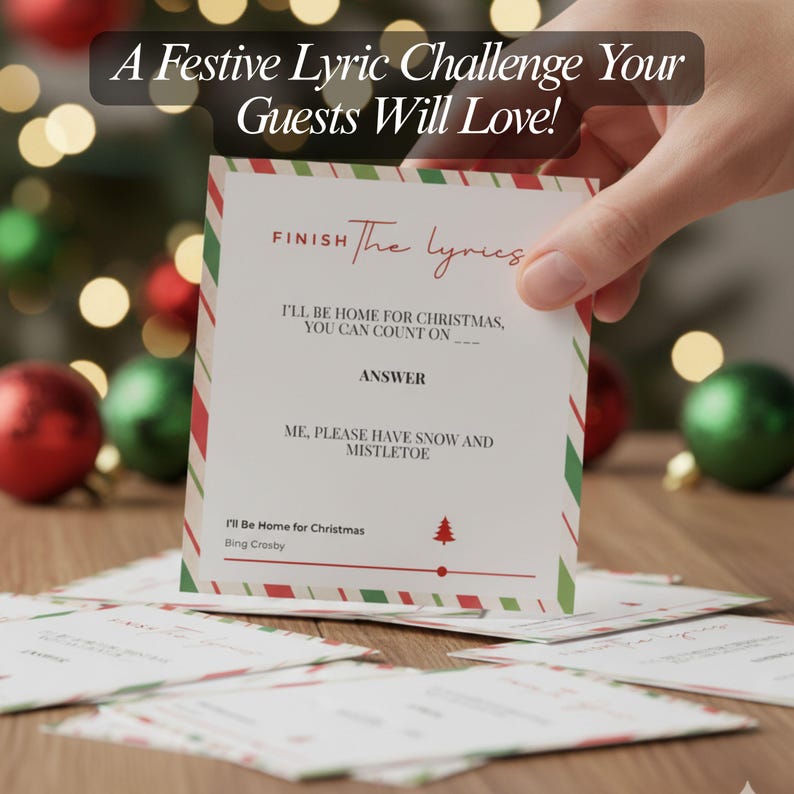 以下が含まれることがあります： 「Finish The Lyrics」のテキストが入ったクリスマスゲームカード。カードには赤と緑のストライプのボーダーがあり、「I'll Be Home for Christmas」の歌詞が含まれています。他のカードは木製の表面にあり、背景にはクリスマスオーナメントがあります。