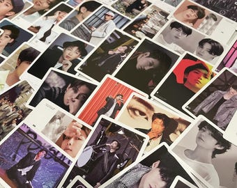 May include: A collection of rectangular photo cards featuring various images of a musical artist. The cards display different poses and outfits, with some cards including text. The color palette includes shades of black, white, red, and blue.