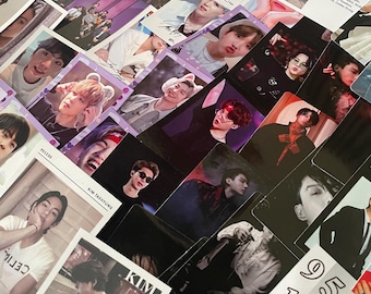 May include: A collection of photo cards featuring various images of a musical group. The cards display individual portraits and group shots, with a mix of color and black-and-white photos. Some cards have text, including names and numbers.