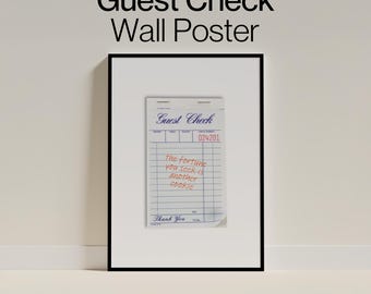 May include: A framed wall poster featuring a white guest check with blue grid lines and text. The check displays the words Guest Check, the number 024201, and the handwritten red text: The fortune you seek is another cookie. The frame is black.