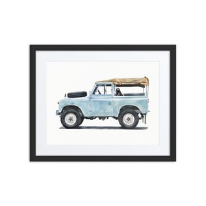 May include: Framed print of a light blue vintage SUV with a tan canvas roof. The vehicle has black tyres and a spare tyre on the bonnet. The artwork is a watercolour style painting.