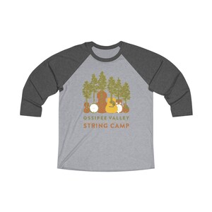 May include: A gray raglan shirt with dark gray sleeves. The front features a graphic of stringed instruments and trees with the text "Ossipee Valley String Camp" in orange.