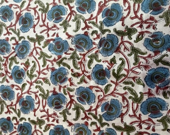 May include: Floral fabric with a repeating pattern of blue flowers, green leaves, and red vines on a white background. The design is dense and detailed, creating a visually rich textile.