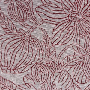 Op de afbeelding: Close-up van een stof met een herhalend bloemenpatroon. Het ontwerp toont grote, gestileerde bloemen en bladeren in een dieprode kleur tegen een lichtbeige achtergrond. Het patroon is gedetailleerd en ingewikkeld, waardoor een getextureerd uiterlijk ontstaat.