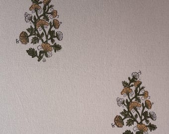 Puede incluir: Tela color crema con un estampado floral repetido. El diseño presenta racimos de flores estilizadas en tonos dorados, blancos y verdes. Las flores están dispuestas sobre un fondo neutro, creando un textil sutil pero decorativo.